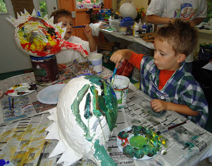 The twins applied their considerable energy and talents to painting colorful dragon piñatas.